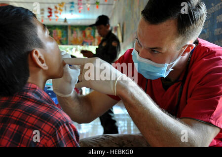 Stati Uniti Navy tenente Matteo Kanter esamina un giovane ragazzo cambogiano durante una igiene dentale outreach evento per Angchhum Trapeang Chhouk scuola nella provincia di Kampot, Cambogia, 15 giugno 2016. Circa 187 bambini della scuola ha ricevuto l'igiene orale e istruzione trattamenti di fluoruro lungo con uno spazzolino da denti e dentifricio da portare a casa come parte del Pacific Angelo 16-2. Pacific Angel include la salute generale, dentale, Optometria, pediatria, la terapia fisica e programmi di ingegneria nonché vari aiuti umanitari e di soccorso in caso di catastrofe esperto in materia di scambi. La missione migliora participa Foto Stock