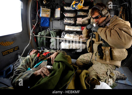 Un U.S. Air Force Pararescueman dal sessantesimo Expeditionary squadrone di soccorso dispiegato per Camp Bastion, Afghanistan, fornisce cure mediche a un afgano che ha subito lesioni gunshot, 8 dicembre, 2009. Il PJs sono in grado di salvare pazienti in qualsiasi situazione che hanno bisogno di cure mediche. (U.S. Air Force foto/Staff Sgt. Angelita Lawrence) Foto Stock