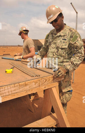 Stati Uniti Navy Petty Officer 1. Classe Orrin Sewell (a destra), navale Mobile Battaglione di costruzione 3, misure rebar aprile 5 per uso nella fondazione della consultazione clinica di Salute la Seabees edificio sono qui. Lo scopo della clinica è di fornire servizi di maternità per le donne locali. La Seabees, assegnato a Camp Lemonnier, Gibuti, opera in tutto il paese la costruzione di cliniche e di altri edifici a sostegno delle Combined Joint Task Force-Horn dell Africa, la cui missione include partner di potenziare la capacità della nazione. Foto Stock