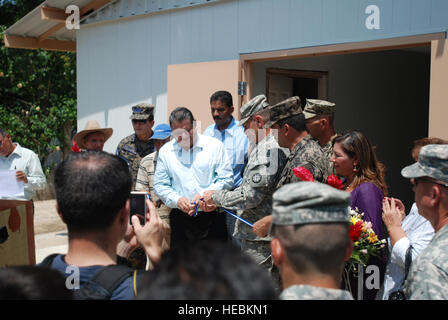 Missouri Guardia Nazionale Lt. Col. Robert Jones, comandante della Task Force Tropic, consente di tagliare il nastro al di fuori della nuova costruzione clinica medica in Ociente, in Honduras il 27 giugno. Il Navy Seabees del Naval Mobile Battaglione di costruzione 23, con sede a Fort Belvoir, Virginia, ha recentemente completato una clinica nella città come parte degli Stati Uniti Esercito del sud al di là dell'orizzonte 2012 esercizio. Foto Stock