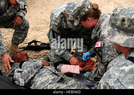 Stati Uniti Army Spc. Janet Pritchard, nativo di Fort Hood in Texas, e membro della sede Service Company, truppe speciali battaglione, 1a divisione di cavalleria, riceve simulato aiuto medico da compagni soldati durante un esercizio su Camp Liberty, Iraq, il 24 aprile. Foto Stock