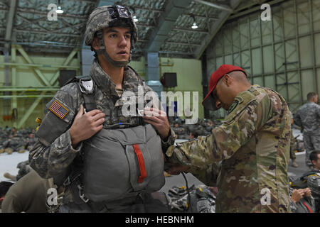 I paracadutisti con la quarta brigata di fanteria combattere Team (airborne), XXV divisione di fanteria, U.S. Esercito di Alaska, rig up prima di un salto come parte di Red Flag Alaska 17-1 a base comune Elmendorf-Richardson, Alaska, Ottobre 12, 2016. Durante il Red Flag-Alaska 17-1, circa 2,095 SERVIZIO DEGLI STATI UNITI membri parteciperanno nell'esercizio - circa 1.295 personale da fuori Alaska e 203 visitatori internazionali. (U.S. Air Force foto di Airman 1. Classe Valerie Monroy) Foto Stock