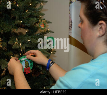 Un partecipante si blocca un ornamento di U.S. Il personale dell'esercito Sgt. Brian Freeman ai superstiti servizi di outreach' holiday ricordo tree, presso la missione 733rd Support Group Sede Centrale, Dicembre 4, 2012. Freeman è morto a Baghdad, Iraq, quando un veicolo-borne improvvisato dispositivo esplosivo detonato vicino la sua pattuglia smontati. (U.S. Air Force foto di Airman 1. Classe R. Alex Durbin/rilasciato) Foto Stock