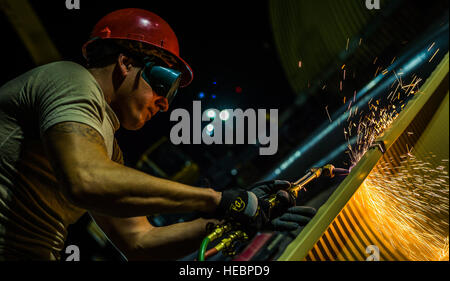 Il personale Sgt. Jesse Mitchell, 557th Expeditionary cavallo rosso squadrone marciapiede e operatore dell' attrezzatura, tagli una struttura di metallo con una torcia soffiante 3 Agosto, 2014, in una località segreta in Asia sud-ovest. Avieri dal 557th ERHS è venuto da Al Udeid di costruire due K-Span edifici di stabilire più strutture permanenti rispetto alla corrente tende utilizzate come terminali di passeggero. Il gruppo è composto da tutti i Air National Guard membri distribuito da Penn. a sostegno dell'Operazione Enduring Freedom. (U.S. Air Force photo by Staff Sgt. Jeremy Bowcock) Foto Stock