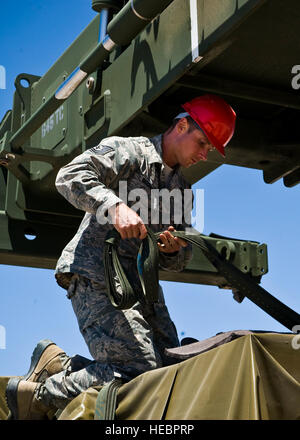 Tech. Sgt. Jason Bischoff, 99th ingegnere civile Squadron NCO in carica della B-Team per il cavallo rosso Airborne, fissa cargo per un giunto di ingresso forzato esercizio 29 maggio 2013, presso la Base Aerea Militare di Nellis Nev. Il 820th cavallo rosso squadrone è in grado di immissione di aria per riparare gli aerodromi danneggiato durante la contingenza e operazioni di guerra. (U.S. Air Force Foto di Airman 1. Classe Jason Couillard) Foto Stock