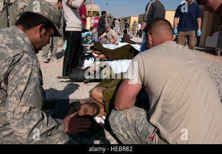 Stati Uniti Army Spc. Colin Byrd (a destra), un 4-73 Cavalleria, ottantaduesima Airborne Division medic assegnati per inoltrare una base operativa Farah, funziona con un interprete assegnato alla sua divisione per ottenere ulteriori informazioni dal suo paziente che è stato ferito per le strade della città di Farah, provincia di Farah, Afghanistan, quando un suicidio bomba è esplosa nov. 20, attorno a 9 a.m. In una vera e propria risposta congiunta per il tragico attentato, membri di Farah Provincial Reconstruction Team, l'ottantaduesima Airborne, civile di appaltatori, Forze Speciali Italiane e la Task Force Italiana immediatamente a sud correva per la classificazione di area e immissione dei punti di controllo o Foto Stock