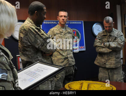 Supporto regionale comando (Sud) Sgt. Il Mag. Timothy Alston parla di recente promosso Sgt. Jason Wilkey prima che egli presenta Wilkey con il Titan del mese award presso l'RSC(S) sede, a Kandahar Air Field, Afghanistan, Marzo 10, 2012. La Titan del mese Award viene assegnato a un soldato della coalizione, airman, marinaio, marine o civile che ha mostrato prestazioni esemplari nei suoi compiti. Wilkey era un assistente funzionario contraente il rappresentante e guida per la polizia nazionale afgana reclutare il punto di raccolta mentre dispiegato per inoltrare una base operativa Walton in Kandahar provin Foto Stock