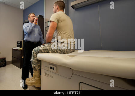 Il Dott. Gregory Johnson, Tripler commozione Clinic direttore medico, ha U.S. Army Spc. Andrew Karamatic, Dipartimento di Medicina combat medic, seguire il suo dito con i suoi occhi durante un esame neurologico, 20 marzo 2014, presso il Tripler Army Medical Center si trova a Honolulu. Dal 2002 al 2013, più di 294,000 servizio militare i deputati hanno subito una lesione cerebrale traumatica. Marzo è designato come National lesione cerebrale Awareness Month. (U.S. Air Force Photo by Staff Sgt. Christopher Hubenthal) Foto Stock