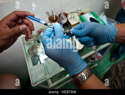 Il cap. Cody Krech illustra come preparare un colpo di anestesia durante un dentista di scambio a Besh Kungei Trauma Center, Kirghizistan, Agosto 16, 2012. Le procedure dentistiche praticati durante lo scambio consisteva di valutazioni orali, pulizie, e le estrazioni. Egli è un 376 Expeditionary gruppo medico dentista distribuita di Scott Air Force Base, Ill. e un nativo di Barlow, Ky. Foto Stock