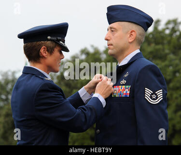 Col. Kristin Goodwin, seconda bomba Wing Commander, presenta Tech. Sgt. Joshua Flood, secondo ingegnere civile Squadron l'eliminazione degli ordigni esplosivi tecnico, la stella Bronze durante il 9/11 ricordo cerimonia su Barksdale Air Force Base, La., Sett. 11, 2014. Alluvione è stato riconosciuto per la guida di una tre-membro della squadra per la sicurezza e la corretta risoluzione di 34 missioni di combattimento mentre distribuito a sostegno dell'Operazione Enduring Freedom. (U.S. Air Force foto/Senior Airman Jannelle Dickey) Foto Stock