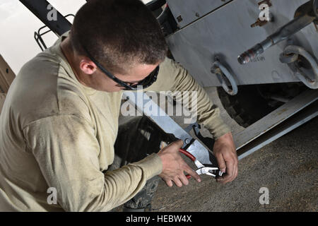 Senior Airman Daniel Suarez, 379 Manutenzione Expeditionary Squadron, fissa un cardine su una barra di traino per un aeromobile unità aria condizionata, 7 maggio 2015, presso l'Al Udeid Air Base, in Qatar. Anche attraverso la bagnato-bulbo temperatura globo indice della bandiera nera condizioni, avieri rimanere resiliente e pratica di misure di sicurezza per garantire la loro wingman stessi e sono protetti dalla estrema sun e il calore di indossare una protezione per gli occhi e talvolta maniche lunghe. (U.S. Air Force photo by Staff Sgt. Alexandre Montes) Foto Stock