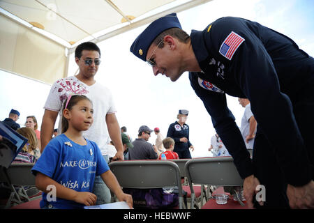 Stati Uniti Air Force Il Mag. Tyler Ellison, U.S. Air Force Thunderbirds dimostrazioni di aria Team operations officer, parla a Lucia Reed, un bambino in Arizona Make-A-desiderio programma, a Davis-Monthan Air Force Base, Ariz., Aprile 11, 2014. I piloti Thunderbirds firmato libri per bambini in Arizona Make-A-desiderio programma nel corso degli eroi giorno. (U.S. Air Force foto di Airman 1. Classe Betty R. Chevalier/rilasciato) Foto Stock