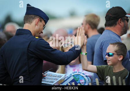 Il Mag. Tyler Ellison, Thunderbird 7, operations officer, interagisce con un giovane ventilatore a seguito delle prestazioni a Battle Creek Campo di Volo Air Show e il Balloon Festival in Battle Creek, Mich, Luglio 5, 2014. (U.S. Air Force foto/Master Sgt. Stan Parker) Foto Stock