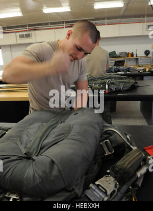 Senior Airman Blake Hill, seconda operazione il supporto Squadron equipaggi apparecchiature di volo, appiattisce un paracadute su Barksdale Air Force Base, La., Marzo 6. Se un equipaggio stati terre nell'acqua indossando un paracadute, lo scivolo provvederà automaticamente a distaccarsi da chi la indossa una volta che il sensore viene bagnata. Foto Stock