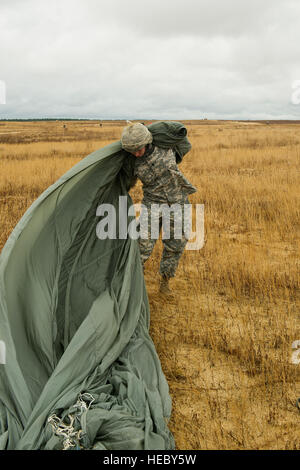 Stati Uniti Army Spc. Kirsten debole, 824th trimestre società Master, pack il suo paracadute, Fort Bragg, N.C., 7 dicembre, 2013. La 16th Annual Randy Oler operazione caduta giocattolo, ospitato dall'esercito degli Stati Uniti per gli affari civili e le operazioni psicologiche il comando (airborne), è il più grande combinati airborne il funzionamento nel mondo dove Fort Bragg di paracadutisti e allied jumpmasters donare giocattoli per essere distribuito agli orfanotrofi per bambini e agenzie di servizio sociale in tutta la comunità locale. (U.S. Air Force foto di Airman 1. Classe Logan Brandt/ Non rivisto) Foto Stock