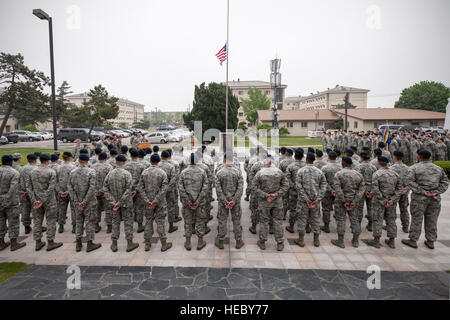 Wolf Pack aviatori stand in formazione in onore delle forze di sicurezza soci che hanno compiuto il sacrificio estremo nella linea del dazio nel corso di una cerimonia di ritiro 15 maggio 2015, a Kunsan Air Base, Repubblica di Corea. I membri del lupo Pack riconosciuto l importanza della prevenzione della criminalità nel corso della polizia nazionale settimana varie osservanze, comprese dimostrazioni da parte dei militari di lavoro sezione cane, la lotta contro le armi e il display delle armi, la prevenzione della criminalità e scenette defender sfida. (U.S. Air Force foto di Senior Airman Katrina Heikkinen/rilasciato) Foto Stock