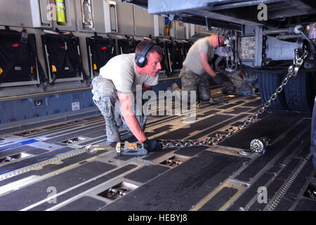 Senior Airman Dane Leblanc, un trasporto aereo viaggio da base comune San Antonio-Lackland, Texas, e Col. John Vaughn, 376 Aria ala Expeditionary Vice comandante dal giunto di base Harbor-Hickam perla, Hawaii, assicurare un corretto angolo di catene per la massima moderazione di 60K Tunner caricatore su una C-17 Globemaster III al Centro di Transito di Manas, Kirghizistan, 7 maggio 2014. Un totale di 28 catene sono necessaria per fornire circa 262 tonnellate di moderazione. (U.S. Air Force foto/Lt. Col. Max Despain) Foto Stock