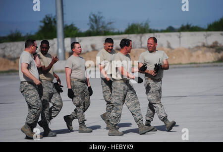 Il porta antenna carico debriefs team un caricamento riuscito a piedi attraverso la pista di atterraggio al Centro di Transito di Manas, Kirghizistan, 7 maggio 2014. Col. John Vaughn, 376 Aria ala Expeditionary vice comandante dal giunto di base Harbor-Hickam perla, Hawaii, così come le antenne porta il team di carico costituito da Senior Master Sgt. Mark Foreman, tecniche Sgt. Steven Moore, Master Sgt. Eric Wilson e il Senior Airman Dane Leblanc, tutti da base comune San Antonio-Lackland, Texas, tornare indietro a piedi fino all'Air Terminal Operations Center, via dopo un caricamento riuscito di un 60K Tunner Loader su un C-17 Globemaster III. (U.S. Foto Stock