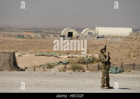 Il personale Sgt. Juan Pareja, 455th Expeditionary forze di sicurezza Squadron Fly-Away Security Team Airman, fornisce la sicurezza come 774th Airlift Expeditionary Squadron C-130 Hercules loadmasters spostare l'ultima porzione di carico da inoltrare una base operativa Sharana, Provincia Paktika, Afghanistan, Sett. 28, 2013. Questa missione ha segnato una pietra miliare retrogrado come il 774th EAS trasportato l'ultimo carico dal FOB Sharana prima che la base viene trasferito al Ministero afghano di difesa. Pareja, un bianco piani, N.Y native, è distribuito da Davis-Montham Air Force Base, Ariz. (USAF foto/Master Sgt. Ben Bloker) Foto Stock