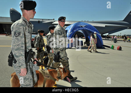 Membri dalla 92ma le forze di sicurezza militari squadrone cane da lavoro unità la pattuglia airfield durante SkyFest 2014 a Fairchild Air Force Base, nello Stato di Washington, 1 giugno 2014. Militare cani di lavoro assistono i loro gestori di eventi in rilevazioni di esplosivi, difesa agli aggressori nonché eseguire pattuglie di sicurezza sulla stazione o ambienti distribuiti.Una stima di 150.000 persone hanno partecipato ai due giorni di air show che comprendeva numerosi aerei statici e le dimostrazioni della AF Thunderbirds e l'esercito cavalieri d'oro. (U.S. Air Force photo by Staff Sgt. Alexandre Montes/rilasciato) Foto Stock