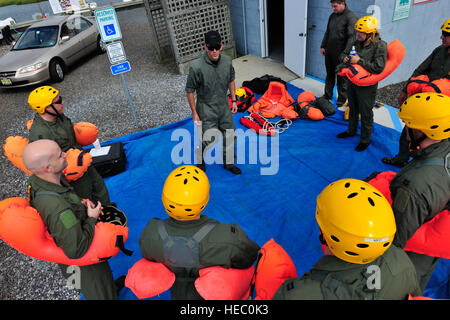 Stati Uniti Avieri con la 305Aria Mobilità ala guarda un istruttore durante l'acqua di formazione di sopravvivenza nella baia vicino Stazione della Guardia Costiera Barnegat Light, N.J., Agosto 18, 2011. Gli studenti poi riferirono le tecniche di nuoto e la zattera di sopravvivenza nella baia prima di un Coast Guard H-65 Delfino elicottero recuperato ogni studente. (U.S. Air Force foto di Tech. Sgt. Parker Gyokeres/rilasciato) Foto Stock