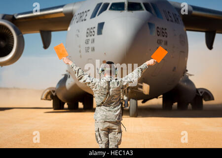 Stati Uniti Air Force Senior Airman Douglas, Prewitt con la 621st risposta di emergenza parafango, esegue il marshalling di un C-17 Globemaster III aeromobili a Geronimo zona di atterraggio durante il giunto Readiness Training Center 14-03 campo esercizio di formazione a Fort Polk, La., gen. 16, 2014. L'esercizio fornisce le unità militari e personale con realistica di pre-distribuzione di scenari di formazione in tutti gli aspetti del conflitto armato. (U.S. Air Force foto di Master Sgt. John R. Nimmo Suor/rilasciato) Foto Stock