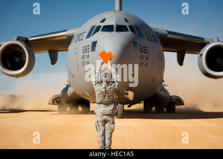 Stati Uniti Air Force Senior Airman Douglas, Prewitt con la 621st risposta di emergenza parafango, esegue il marshalling di un C-17 Globemaster III aeromobili a Geronimo zona di atterraggio durante il giunto Readiness Training Center 14-03 campo esercizio di formazione a Fort Polk, La., gen. 16, 2014. L'esercizio fornisce le unità militari e personale con realistica di pre-distribuzione di scenari di formazione in tutti gli aspetti del conflitto armato. (U.S. Air Force foto di Master Sgt. John R. Nimmo Suor/rilasciato) Foto Stock