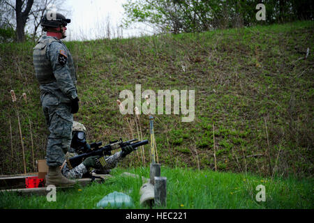 Stati Uniti Navy Corpsman ospedale di prima classe Giuseppe Topp, inferiore con il Farah Provincial Reconstruction Team, spara un M203 lanciagranate da una volpe foro, con la sua maschera a gas su come parte della qualifica di armi a Camp Atterbury, Ind., 15 aprile 2011. (U.S. Air Force foto di Senior Airman Alexandra Hoachlander/rilasciato) Foto Stock