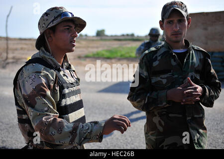 I membri dei figli di Iraq parlare con gli Stati Uniti Soldati da Alfa batteria, 2° Battaglione, XXXII Campo reggimento di artiglieria, quarta brigata Team di combattimento, 1° Divisione di Fanteria, su possibili problemi di sicurezza in corrispondenza di posizioni di polling per le prossime elezioni nazionali nella città di Wynot, nei pressi di Tikrit, Iraq, nov. 16. Foto Stock