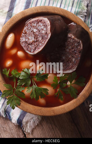 Zuppa di fagioli con salsiccia Morcillo vicino fino in una ciotola. verticale vista superiore Foto Stock