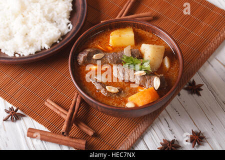 Tailandese tradizionale carni bovine massaman curry con arachidi e contorno di riso orizzontale. Foto Stock