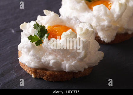 Uova Orsini: panna cotta bianchi e tuorlo su pane tostato su un tavolo. Orizzontale di close-up Foto Stock