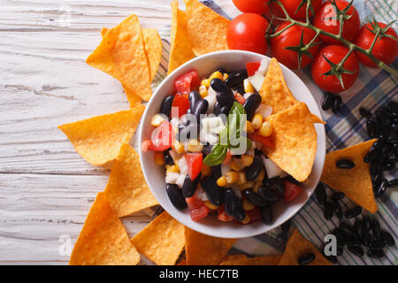 Salsa messicana con i fagioli in una terrina e corn chips nachos sul tavolo di close-up. vista orizzontale dal di sopra Foto Stock