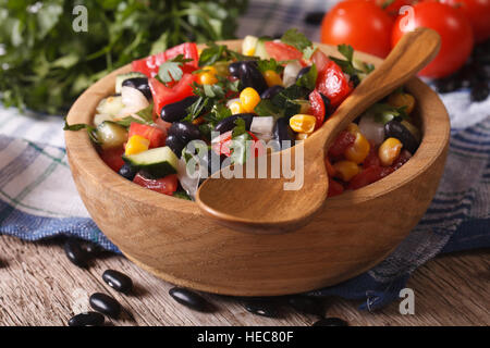 Mexican insalata di verdure nel piatto in legno closeup e gli ingredienti sul tavolo orizzontale. Foto Stock