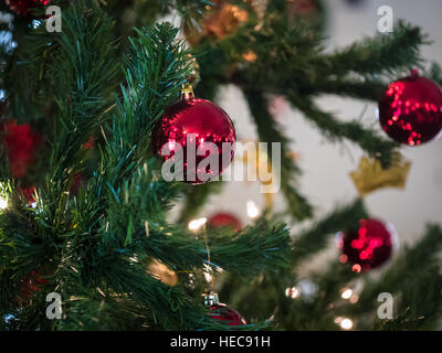 Vista dettagliata del rosso e argento sfera pendente da un albero di Natale decorato Foto Stock