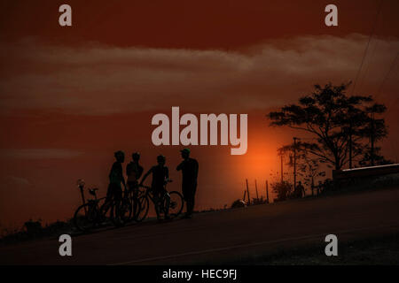 I ciclisti si è fermato a riposare su una montagna al tramonto. Foto Stock