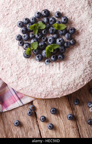 Deliziosa mirtillo cheesecake con noce di cocco e menta vicino sul tavolo. verticale vista superiore Foto Stock