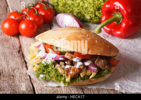 Fast Food: Döner Kebab con carne e verdure e patate fritte vicino sul tavolo orizzontale. Foto Stock