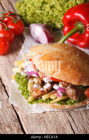 Deliziosi kebab con carne e verdure e patate fritte vicino sul piano verticale. Foto Stock