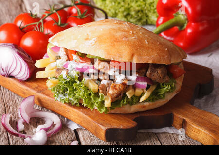 Döner Kebab con carne e verdure e patate fritte vicino sul tavolo orizzontale. Foto Stock