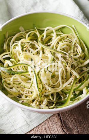 Alimento naturale: materie zucchine la pasta in una ciotola vicino sul tavolo. In verticale Foto Stock