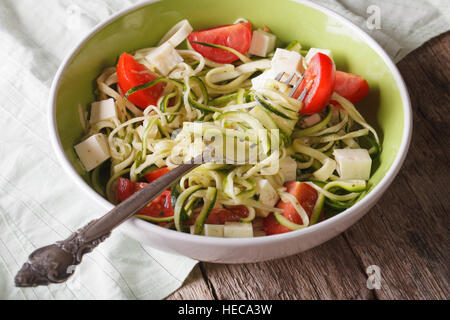 Gli spaghetti di zucchine con feta e pomodori vicino fino in una ciotola. orizzontale Foto Stock