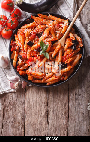 Il cibo italiano: la pasta alla norma sul tavolo e ingredienti. verticale vista superiore Foto Stock