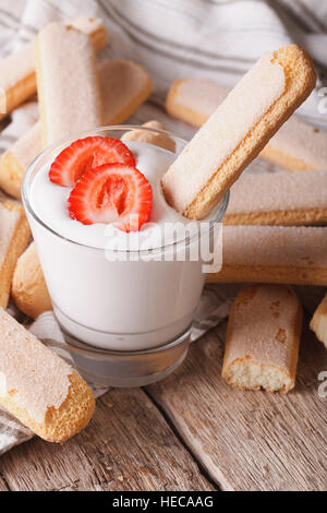 Savoiardi deliziosi biscotti con fragole yogurt in un vetro verticale. Foto Stock