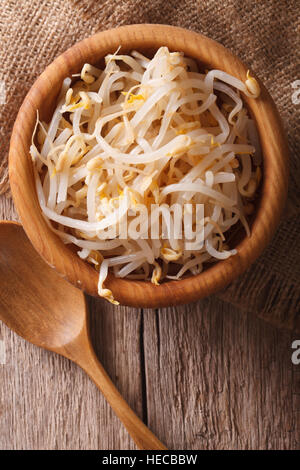 Materie germogli di fagioli in una ciotola di legno sul tavolo. verticale vista superiore Foto Stock