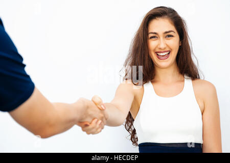 Bella donna d'affari in un abbigliamento casual elegante stringono le mani con il collega di sesso maschile - business il concetto di partenariato e trattative commerciali Foto Stock