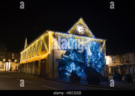 Alberi di Natale e le luci intorno al mercato casa durante la notte. Tetbury, Gloucestershire, Inghilterra Foto Stock