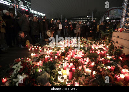 Berlino, Germania. Xx Dec, 2016. I membri del pubblico laico di fiori e candele al di fuori della Chiesa Gedaechtnis a Berlino, Germania, 20 dicembre 2016. Un servizio è stato tenuto a memorialise le vittime di un sospetto attacco terroristico su un mercato di Natale a Berlino durante la quale almeno 12 persone sono state uccise e un altro 50 gravemente ferito da un aggressore sconosciuto che ha guidato un automezzo pesante nell'affollato mercato. Foto: Jörg Carstensen/dpa/Alamy Live News Foto Stock