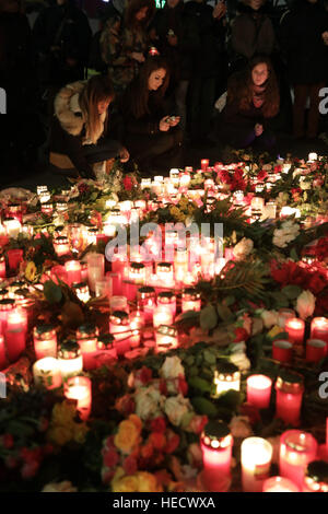 Berlino, Germania. Xx Dec, 2016. I membri del pubblico laico di fiori e candele al di fuori della Chiesa Gedaechtnis a Berlino, Germania, 20 dicembre 2016. Un servizio è stato tenuto a memorialise le vittime di un sospetto attacco terroristico su un mercato di Natale a Berlino durante la quale almeno 12 persone sono state uccise e un altro 50 gravemente ferito da un aggressore sconosciuto che ha guidato un automezzo pesante nell'affollato mercato. Foto: Jörg Carstensen/dpa/Alamy Live News Foto Stock