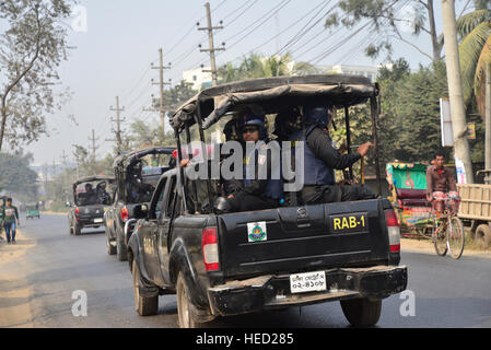 Dacca in Bangladesh. Xxi Dec, 2016. Bengalese azione rapida battaglione (RAB) convoglio di guardia di chiudere la fabbrica di indumenti area Ashulia alla periferia di Dhaka, Bangladesh. Il 21 dicembre 2016 un totale di 59 indumento fabbriche di Ashulia nella periferia di Dhaka è stata dichiarata chiusa in faccia di agitazioni sindacali come migliaia di lavoratori sono state dimostrando per aumentare i salari. Credito: Mamunur Rashid/Alamy Live News Foto Stock